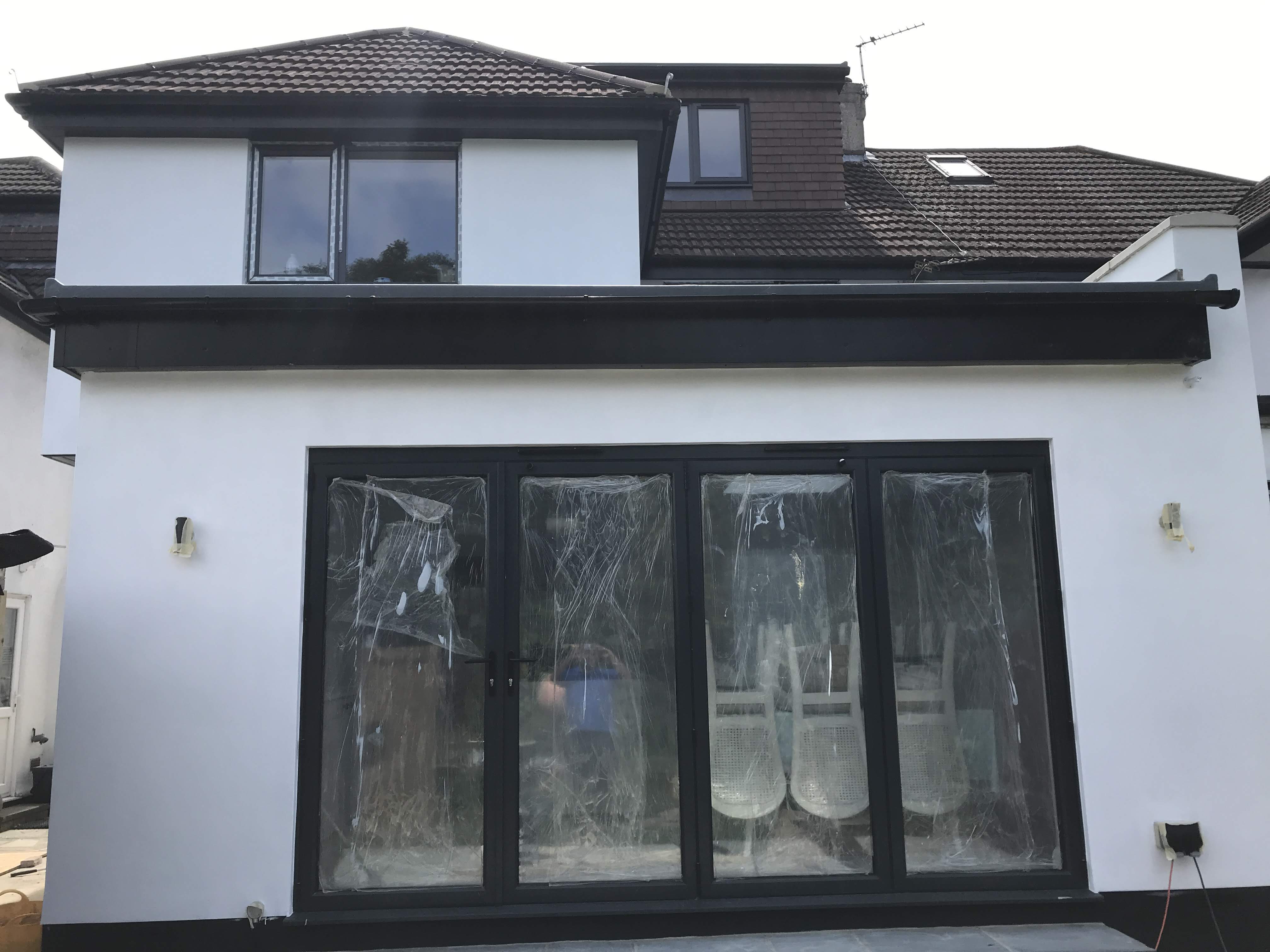 Southborough Lane, Bromley: white-rendered rear extension with slim black bifold doors and a tiled dormer above