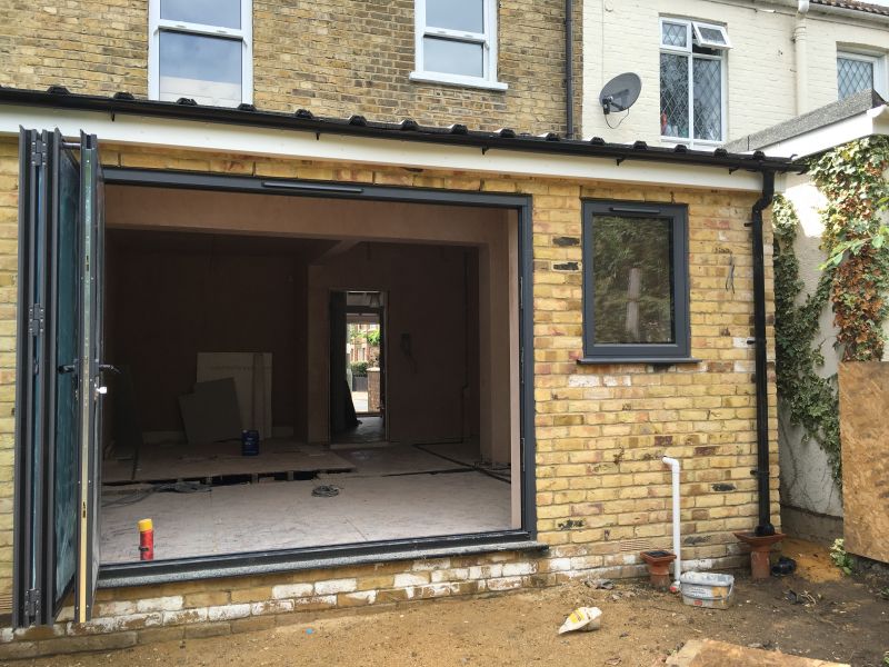 Rear extension under construction with large open bifold doors and newly installed windows