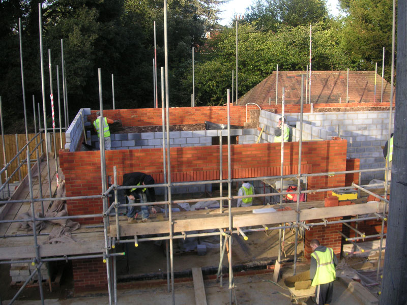 Brick and block walls rising with scaffolding during construction
