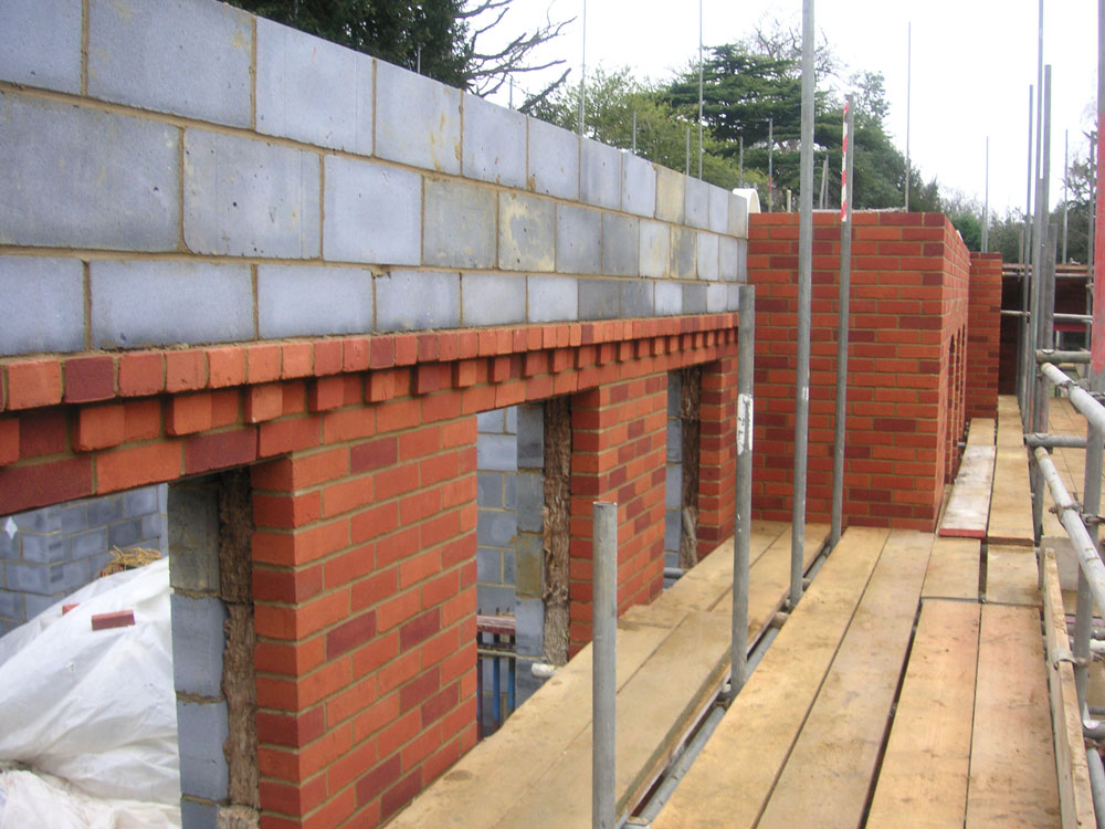 Brick and block outer walls with detailed brickwork under construction