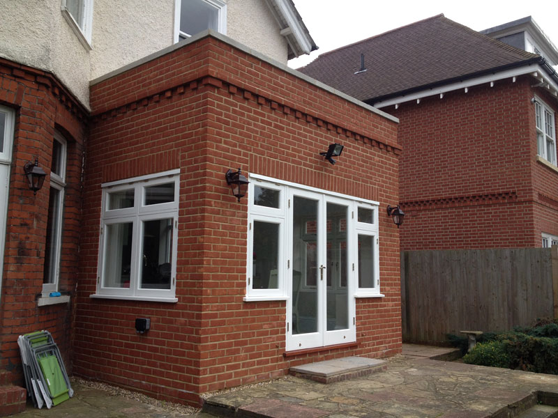 Red-brick extension with white glazed doors and windows